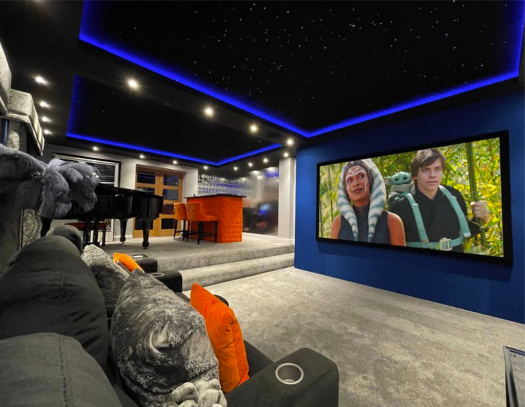 Large home cinema with screen showing star wars and inbuilt blue lighting with spotlights