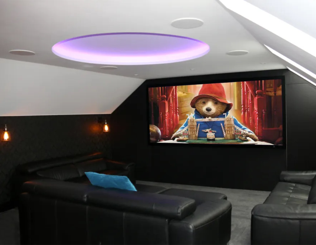 Cinema loft room with large screen showing paddington bear with purple inbuilt mood lighting